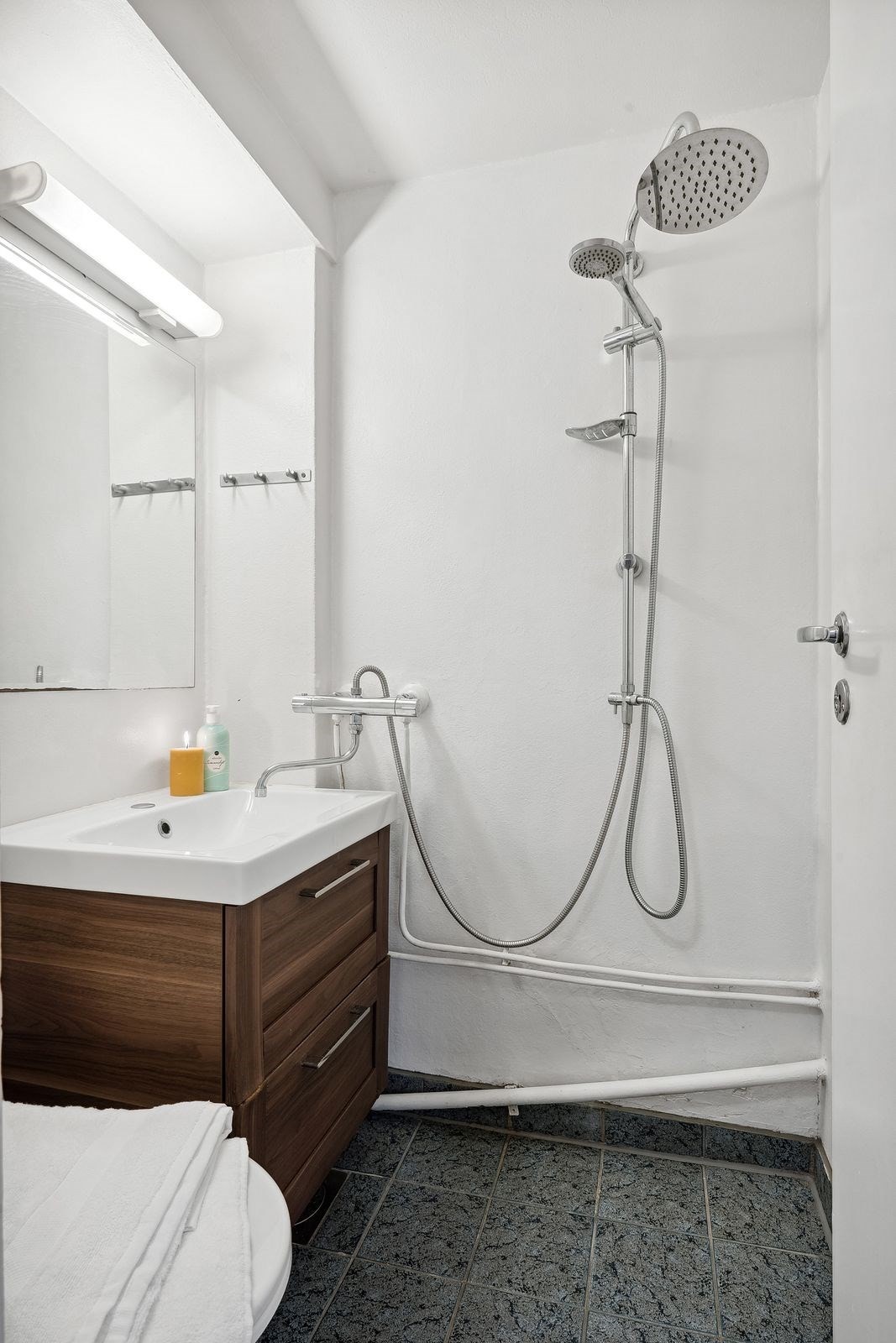 Badet er innredet med dusjsone, servant med innredning, speil med overlys og toalett. Galleribilde