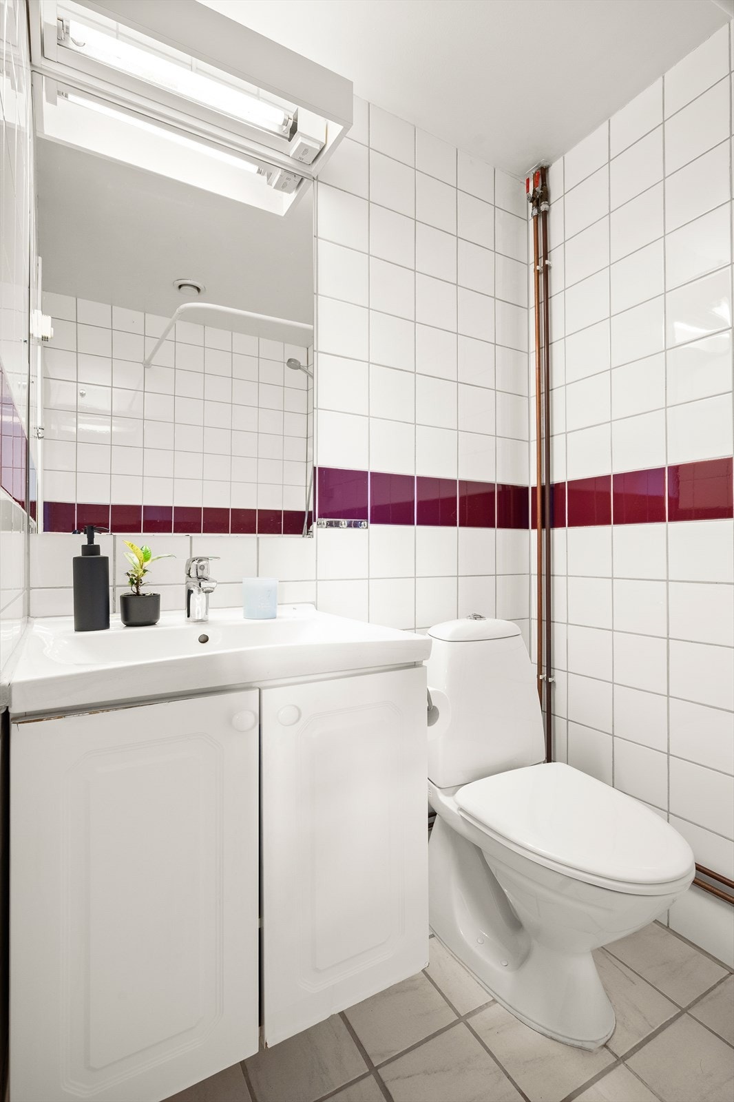 Badet er innredet med gulvmontert toalett, baderomsinnredning med heldekkende servant og dusj med forheng. Galleribilde