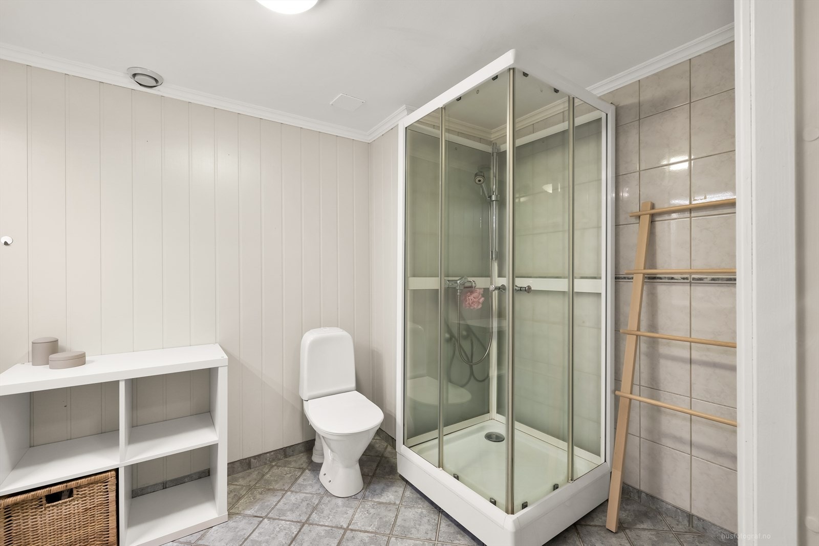 Badet inneholder dusjkabinett, toalett og servant med underskap Galleribilde