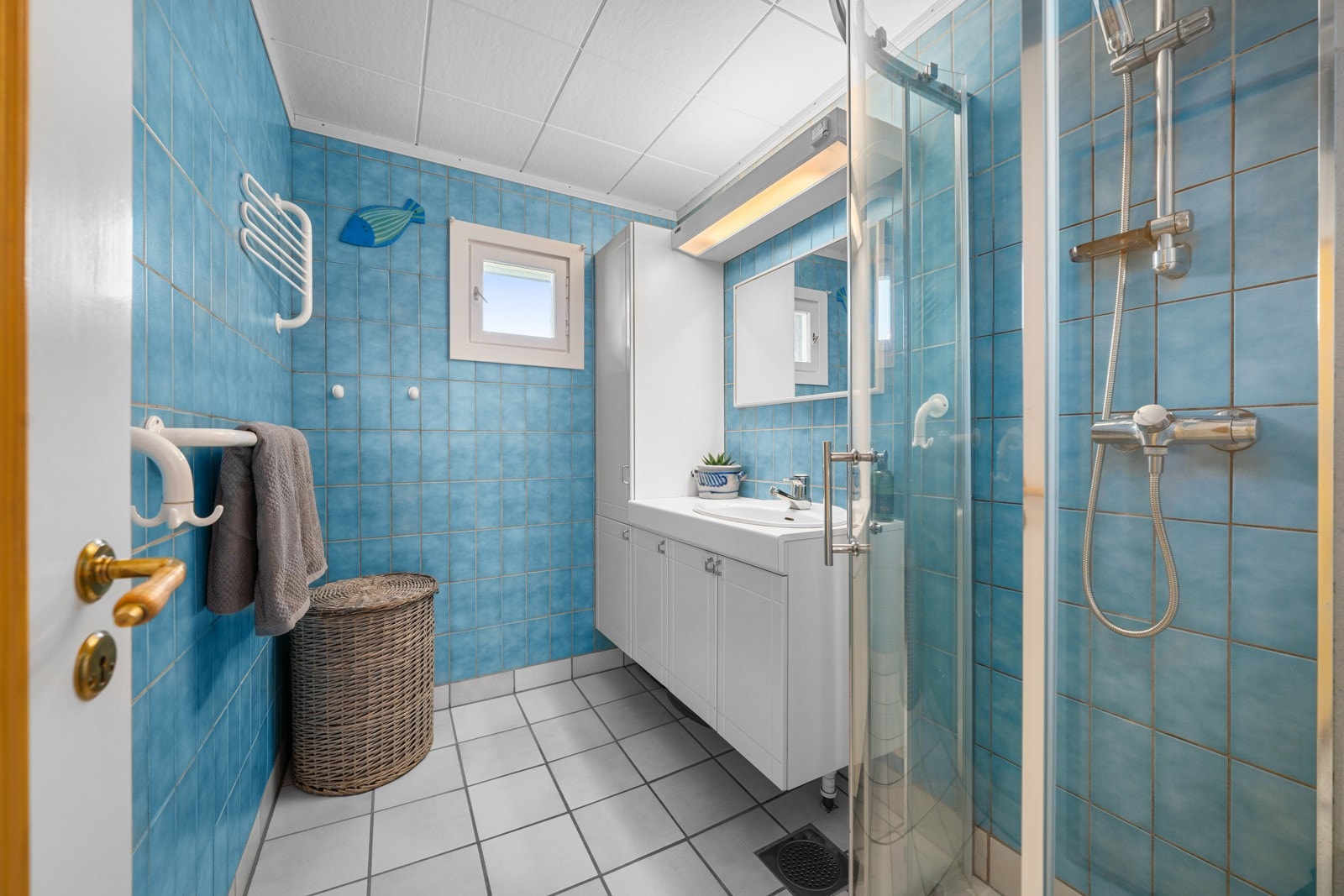 Boligen inneholder et bad, et wc-rom og et vaskerom. Badet har blå fliser på veggene og hvite fliser på gulv med gulvvarme. Galleribilde