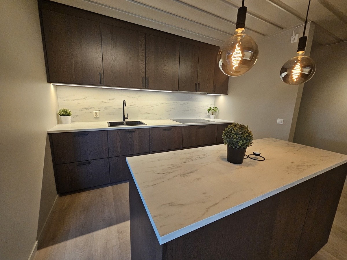 På denne siden av kjøkkenet finner du vask, blandebatteri, platetopp med fem soner og integrerte hvitevarer som oppvaskmaskin og ventilator. Galleribilde