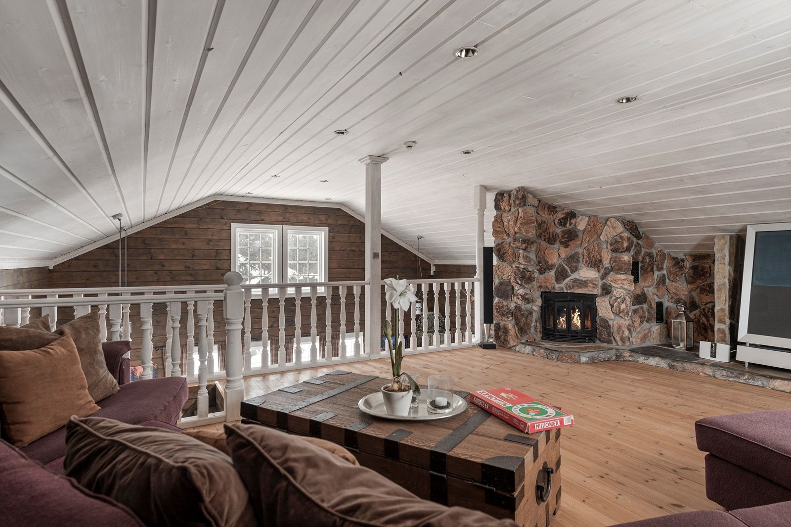 Hemsen har god plass for både sofagruppe og godstoler. I rommet er det en flott steinsatt peisinnsats med hylleplass på vegg. Galleribilde