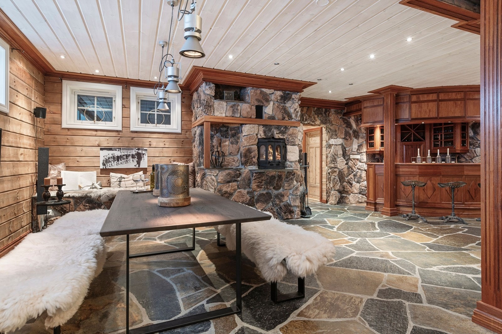 I kjellerstuen er det god plass for å innrede etter eget ønske. I dag er det en barløsning i ett hjørne, samt en stor spisestuedel foran den flotte peisinnsatsen. Galleribilde