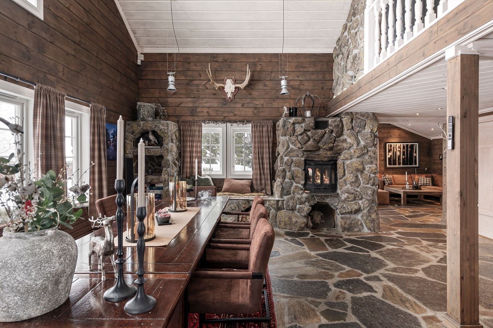 I den koselige spisestuen er det en romslig og rustikk peis med hyller og benk under vindu. Galleribilde