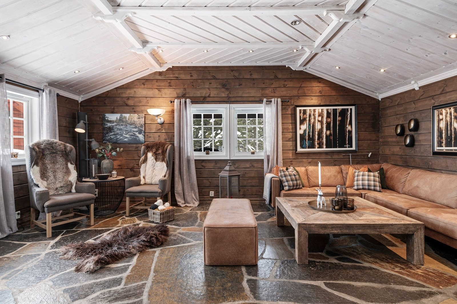 Stuerommet er i dag innredet med en romslig sofagruppe, samt to godstoler foran peisen. Et godt sted å slappe av i etter en lag dag i friluft. Galleribilde