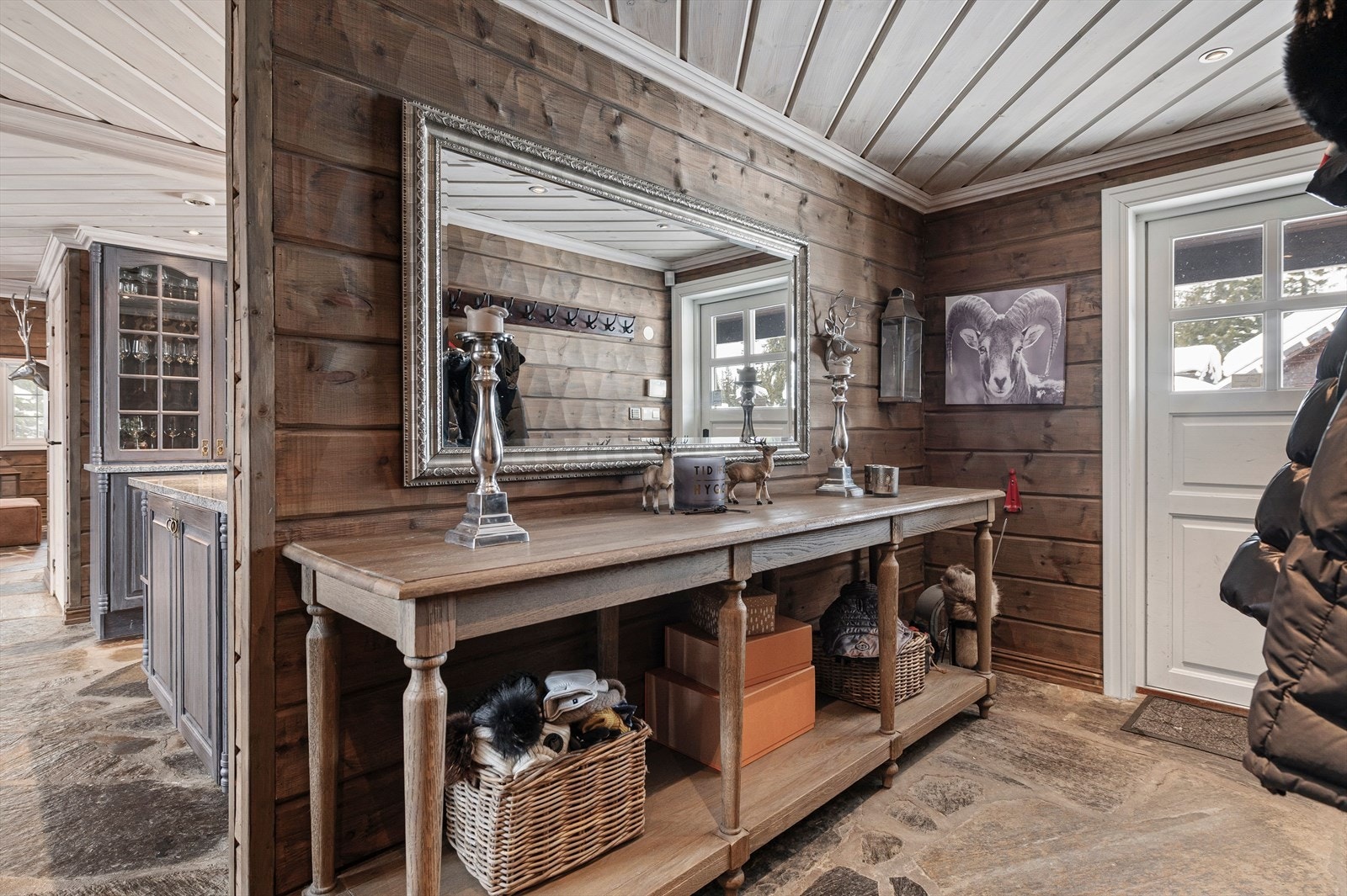 Med en gang du kommer innenfor døren merker du hytta sin lune og gode atmosfære. Her er det kvalitetsskifer på gulv i alle dagligrom med varmekabler under. Merk også den flotte panelen som er beiset i en behagelig fargevalg. Galleribilde