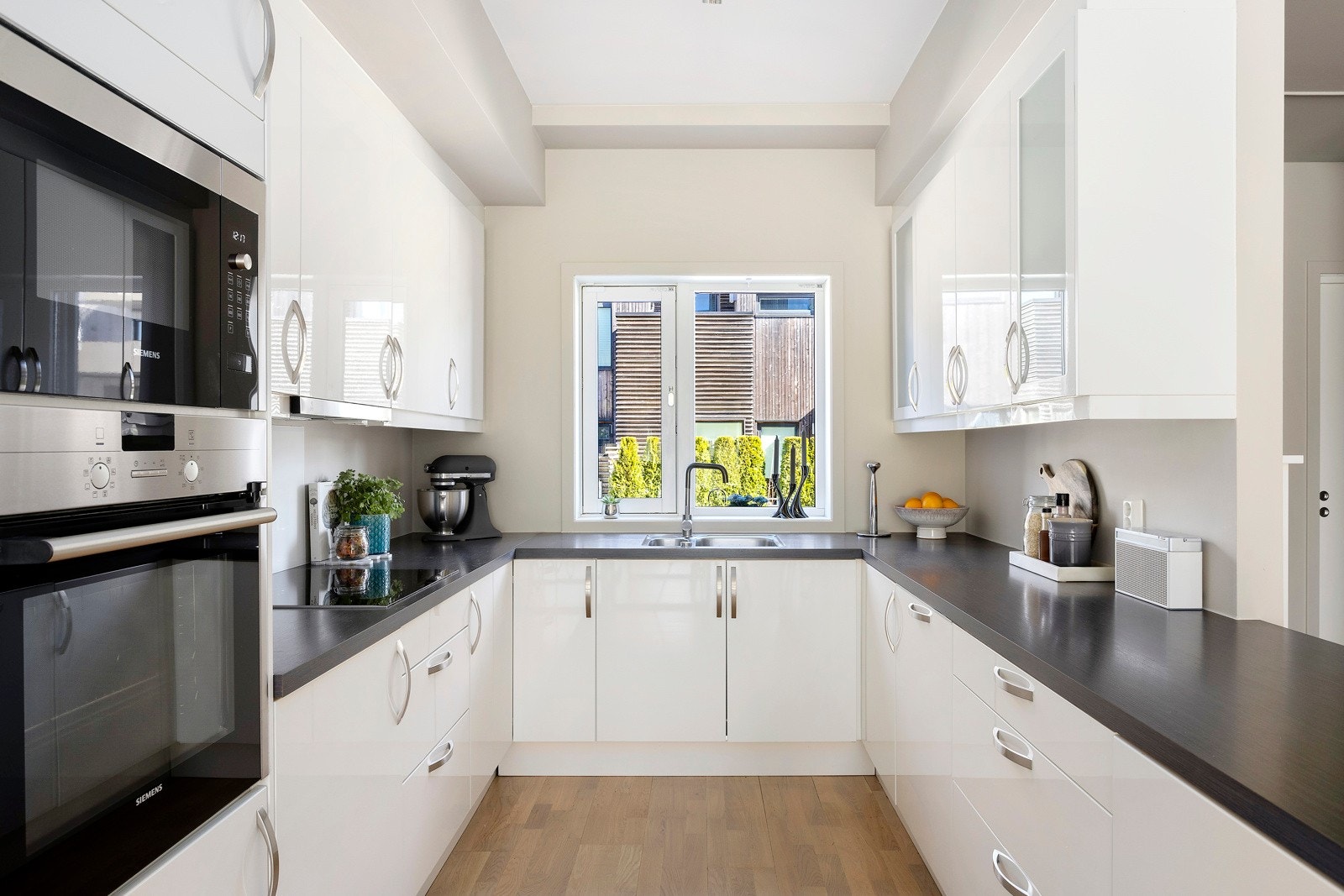 Et lyst og tidløst kjøkken med god benkeplass og fin kombinasjon av skap og skuffer. Galleribilde