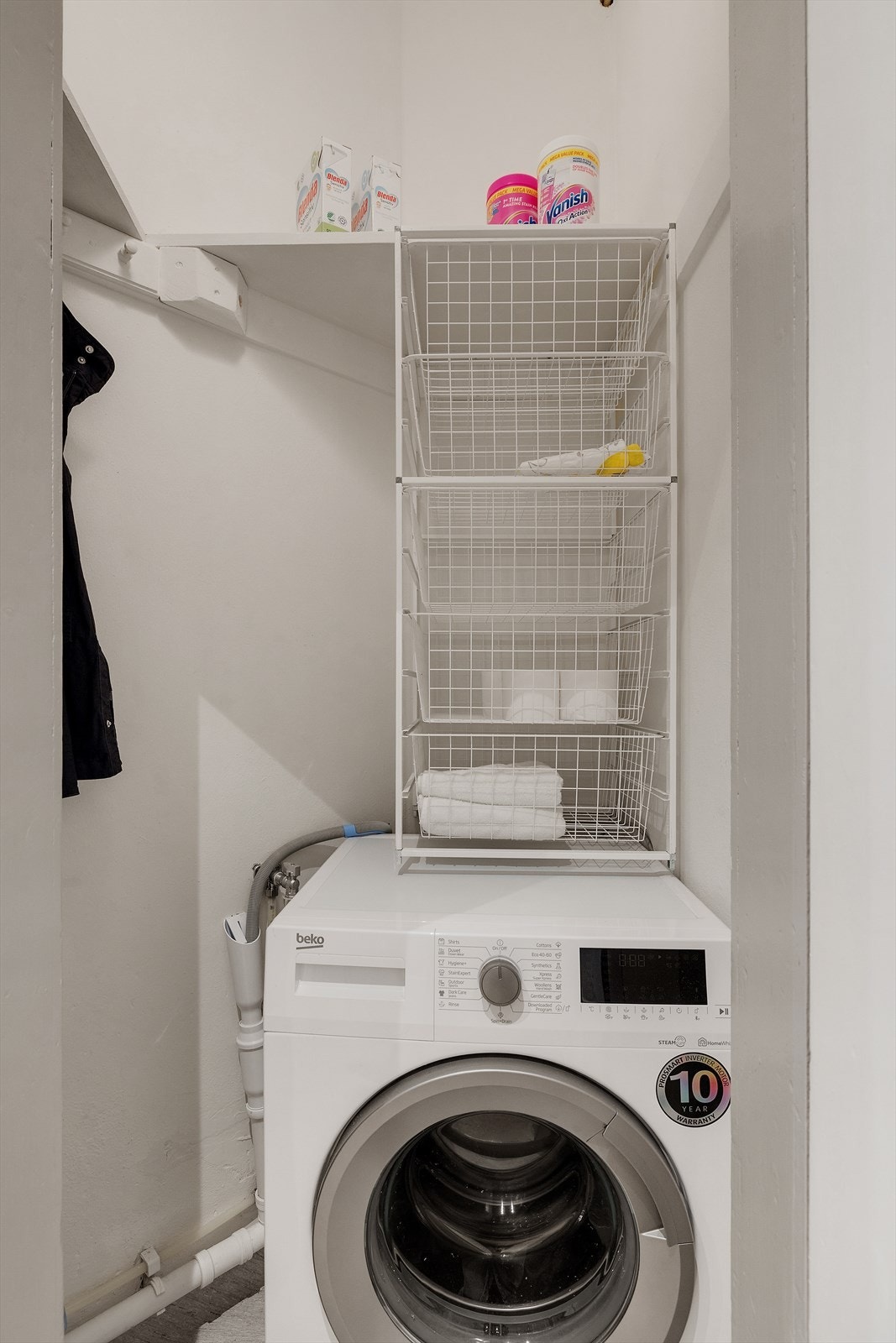 Dør inn til praktisk bod med hyller og opplegg for vaskemaskin. Galleribilde