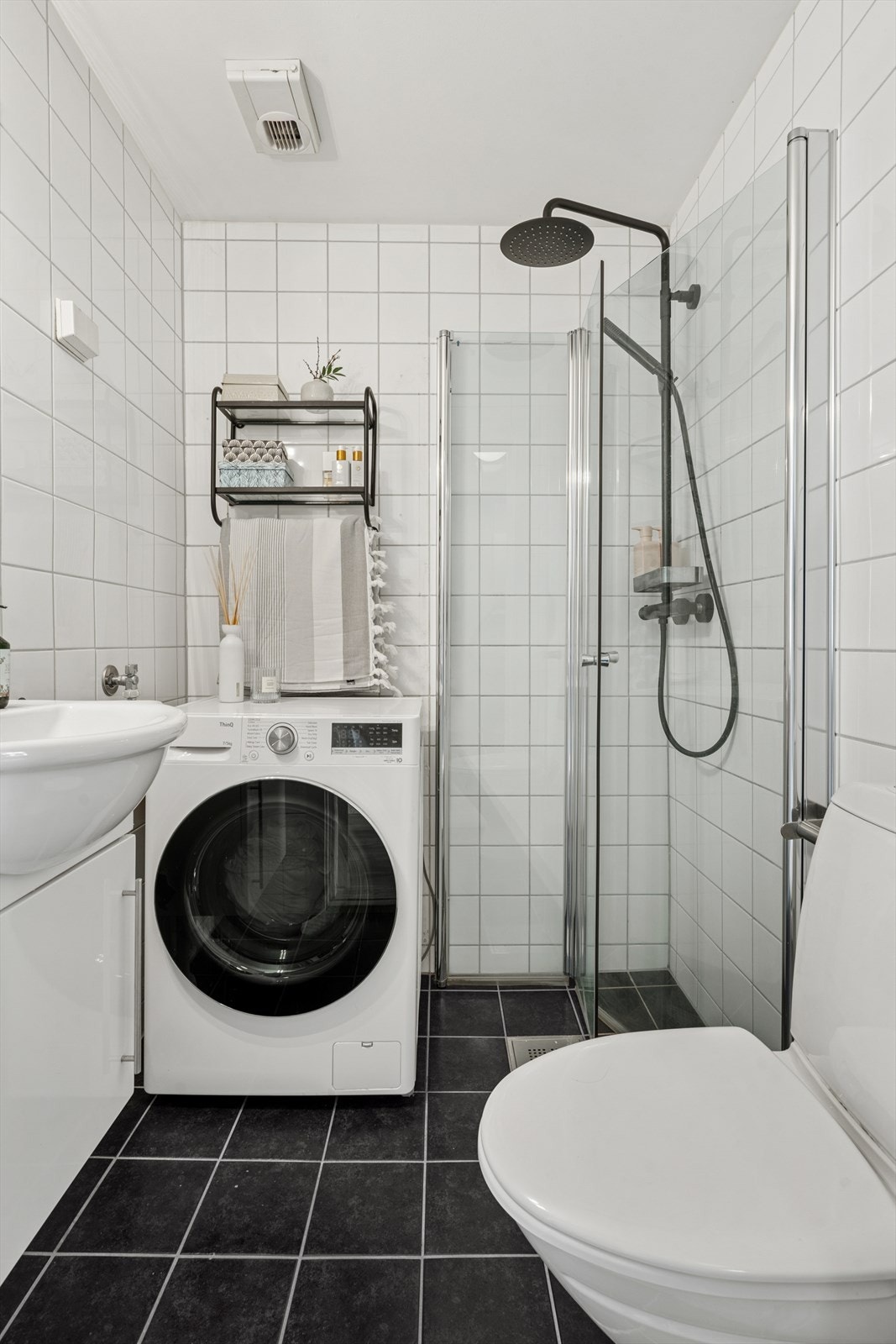 Badet er utstyrt med toalett, servant med underskap, speil og belysning over servant, svingbare dusjdører, regnfallsdusj og hodedusj. Galleribilde