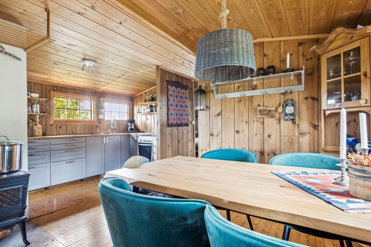 Kjøkken og spisestue. Det er både vedovn og peis i hytta Galleribilde