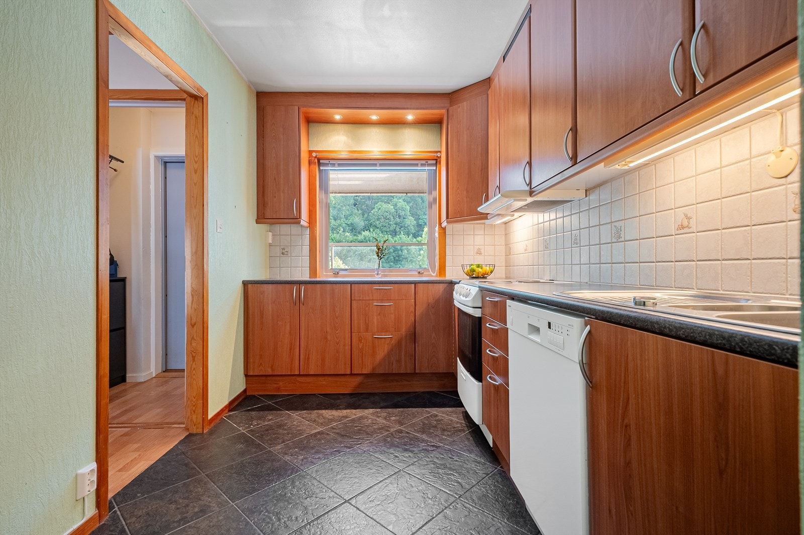 Kjøkkeninnredning med slette fronter og laminert benkeplate. Galleribilde