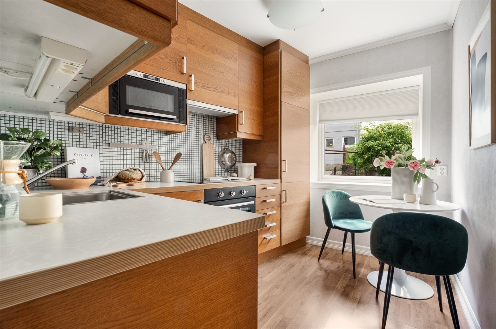 Kjøkkeninredning med slette fronter, laminat benkeplate og fliser over benkeplate. Galleribilde