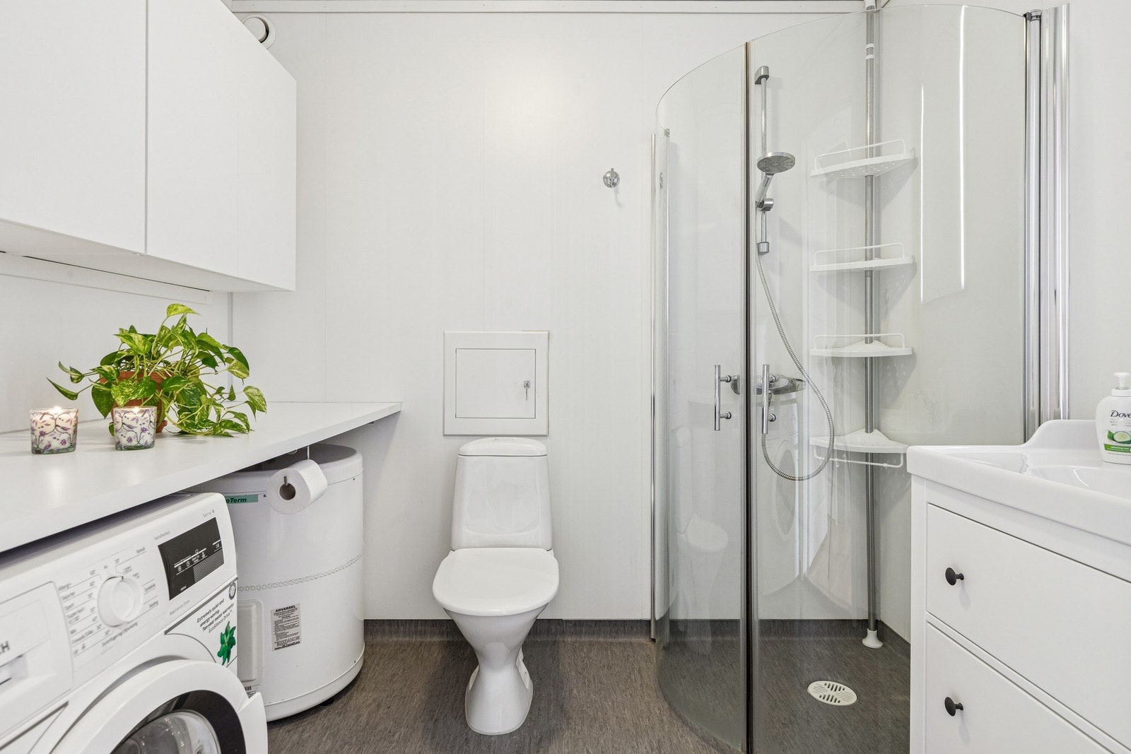Baderommet er romslig og innredet med dusjkabinett, toalett, servant og opplegg for vaskemaskin Galleribilde