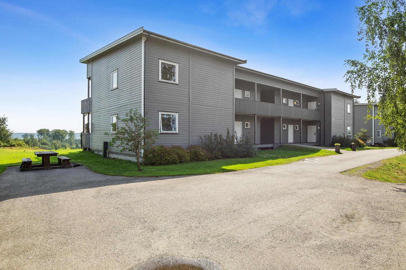 Fellesområdene er pent opparbeidet med plen og sittegrupper, perfekt for sosiale sammenkomster eller rolige stunder i grønne omgivelser. Galleribilde