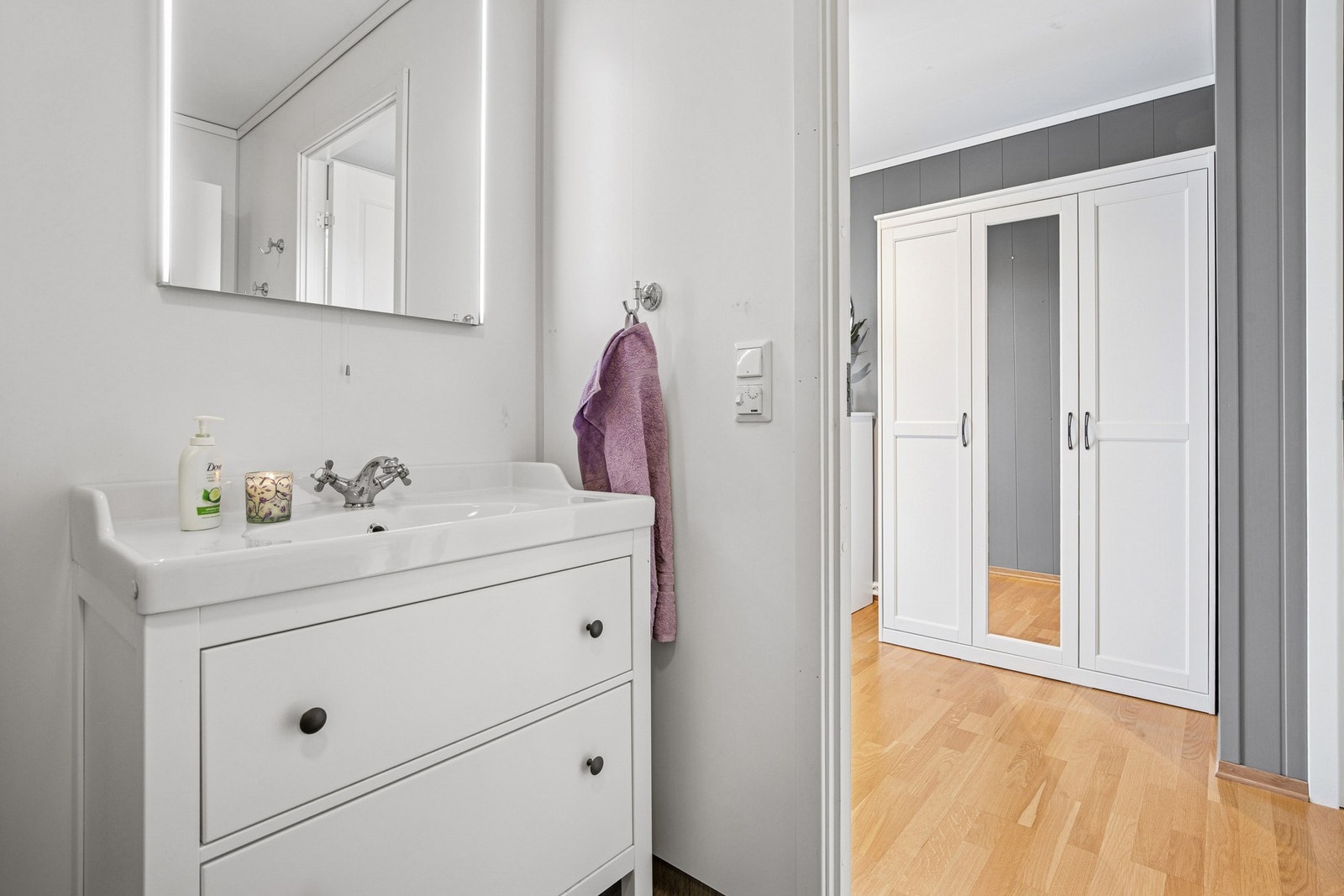 I tillegg til dusjkabinett og praktisk servantinnredning, er badet utstyrt med gulvvarme, perfekt for kalde morgener og ekstra komfort i hverdagen. Galleribilde