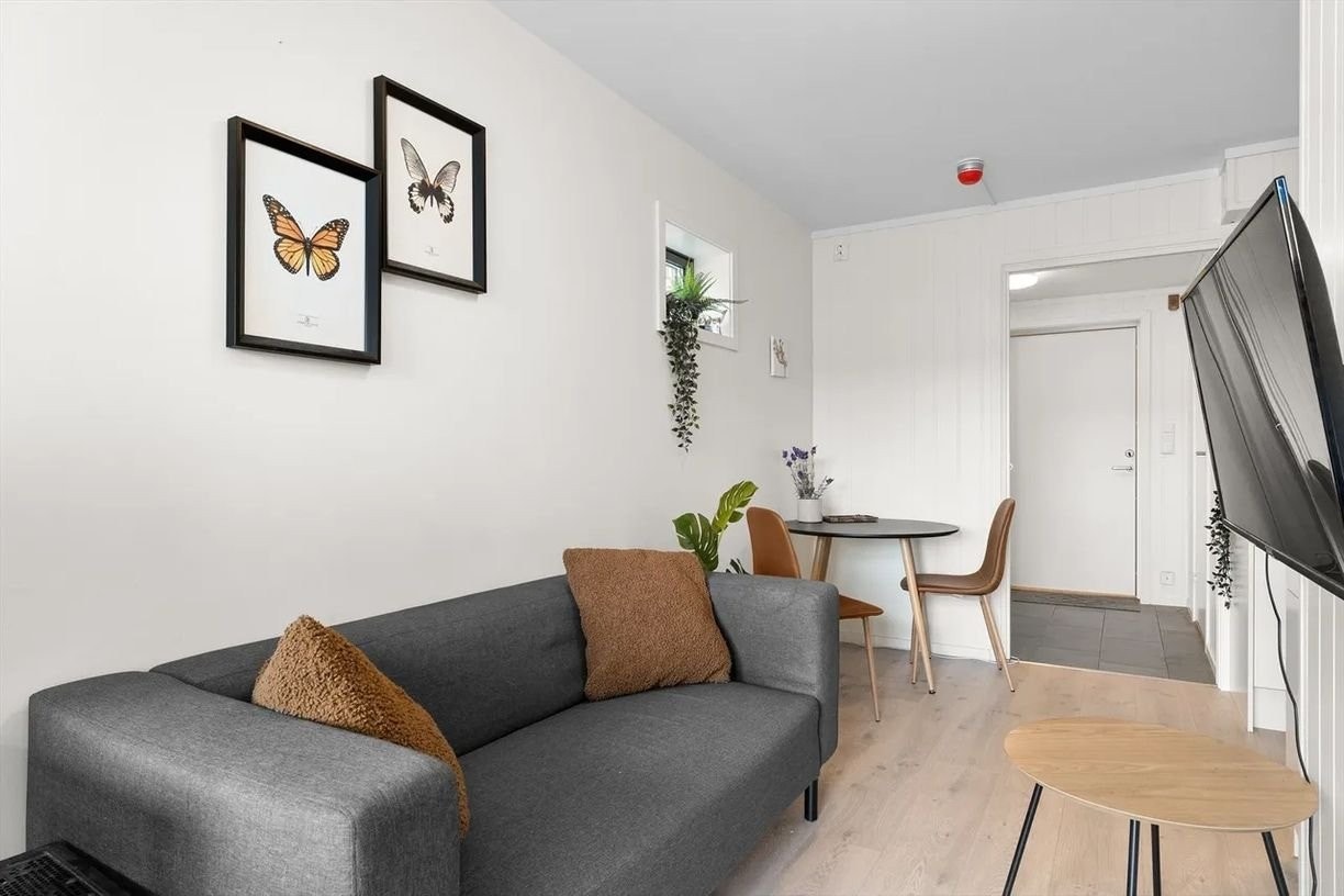 Trivelig stue med varme fargetoner og delikate detaljer – åpen løsning mot spiseplass og entré gir en god romfølelse og praktisk bruk av arealet. Galleribilde