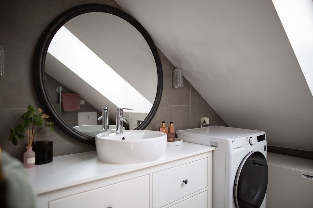 Badet er flislagt og ustyrt med vaskemaskin. Galleribilde