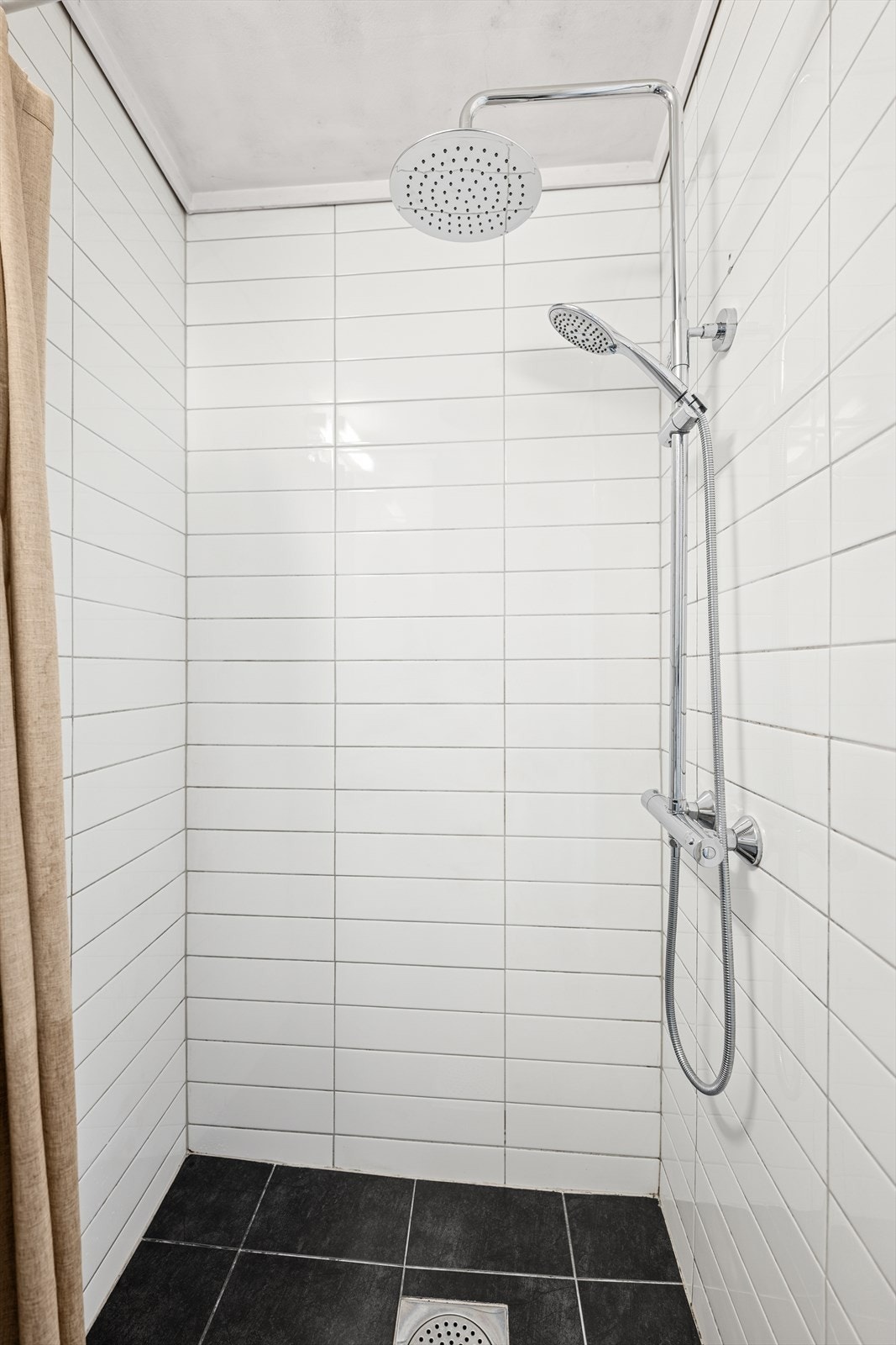 Badet er praktisk innredet med dusjnisje, vegghengt speil, servant og toalett. Et funksjonelt rom med behagelig atmosfære. Galleribilde