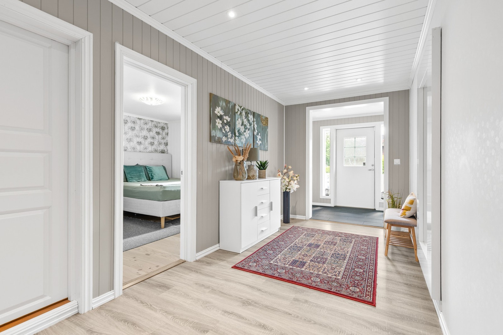 Gang/entré med fliser og laminat på gulv, og panel på vegger samt i himling Galleribilde