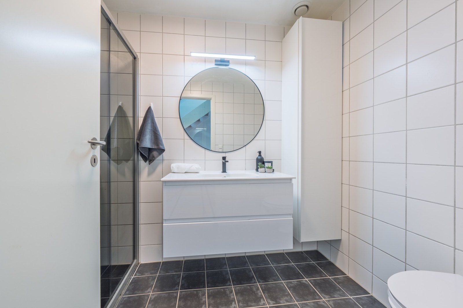 Badet er utstyrt med vegghengt klosett, servant og dusjhjørne. Galleribilde