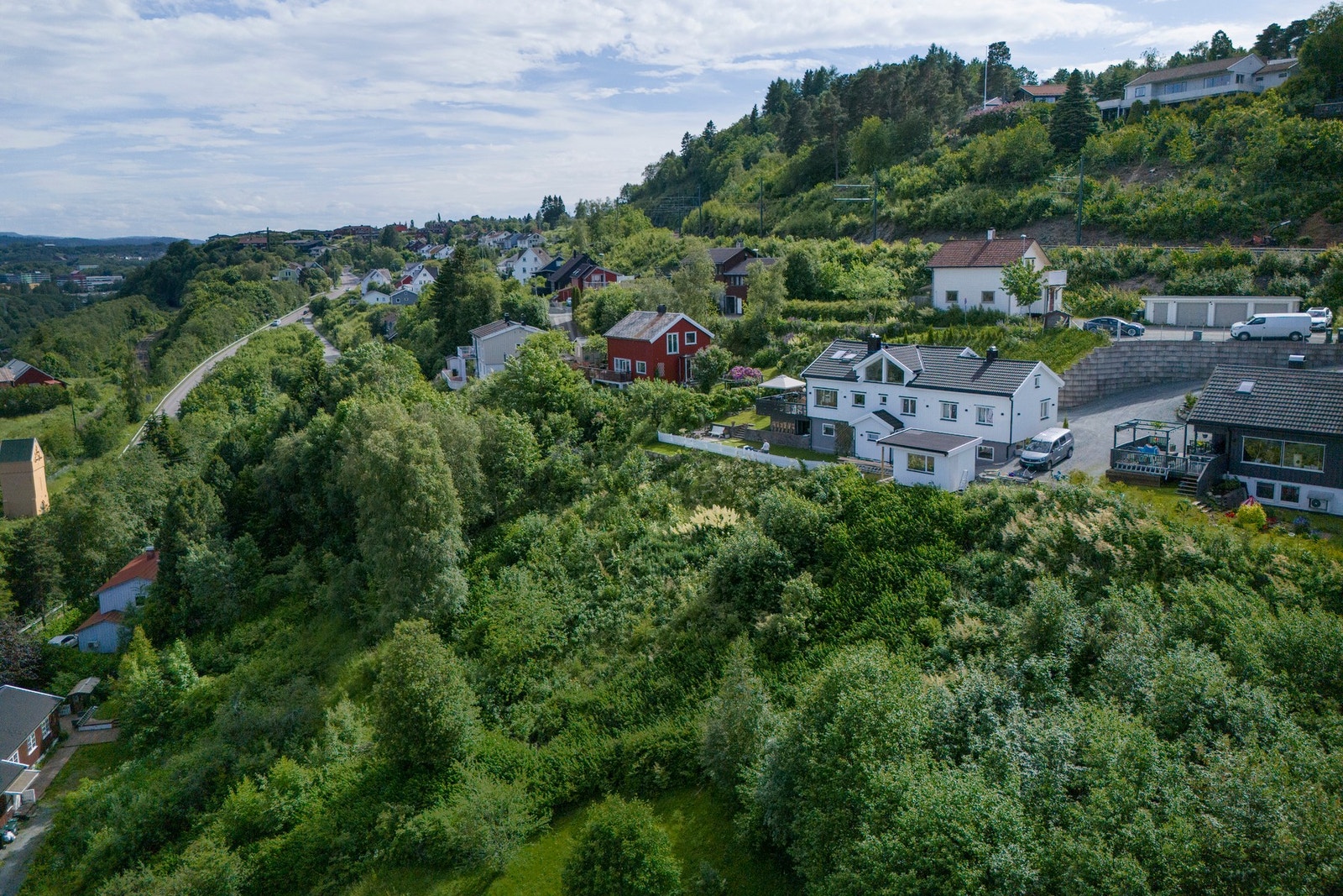 Tomten ligger på nedsiden av det hvite huset. Galleribilde