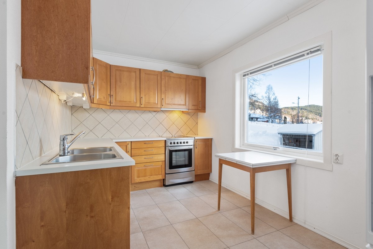 Det er montert en romslig, L-formet innredning, og rommet har god plass til spisebord Galleribilde