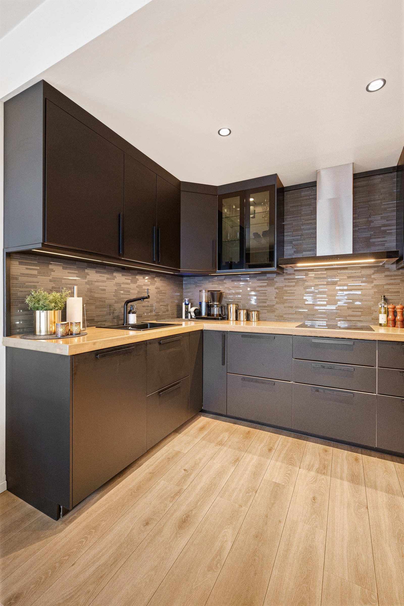 Kjøkket har moderne svart innredning og er utstyr med integrert stekeovn, kombiovn, platetopp, oppvaskmaskin og kjøleskap med fryser og isbitmaskin. Galleribilde