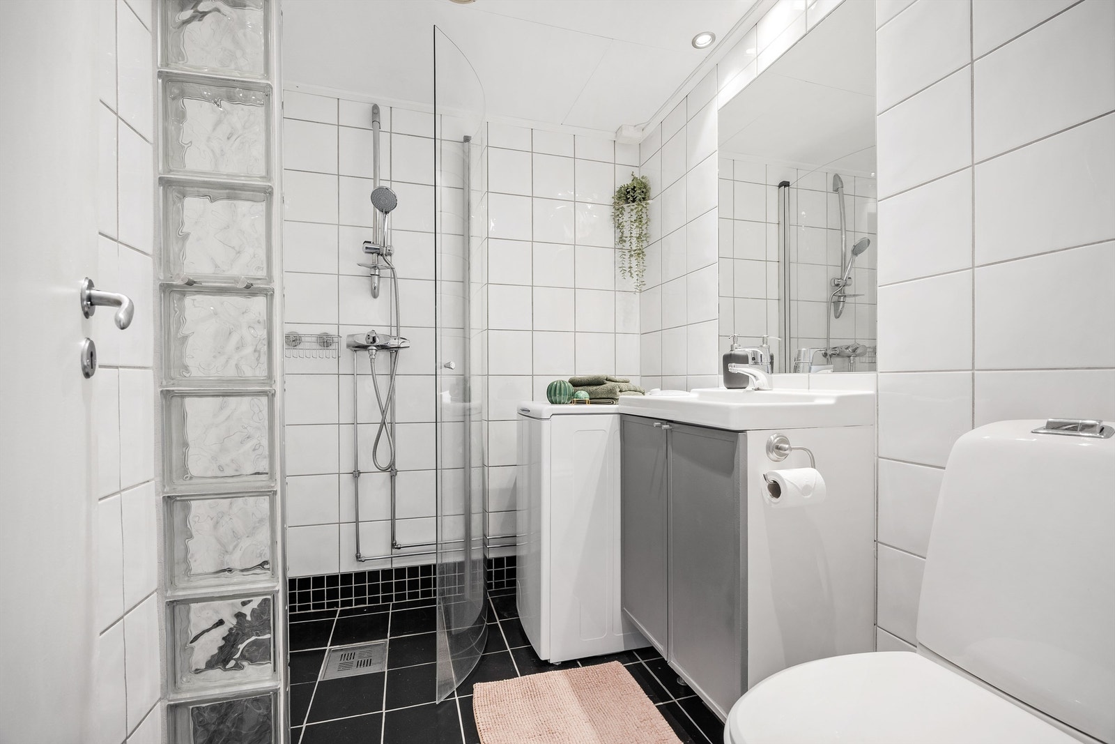 Bad med flislagte vegger og gulv med varmekabler i gulvet samt opplegg for vaskemaskin Galleribilde