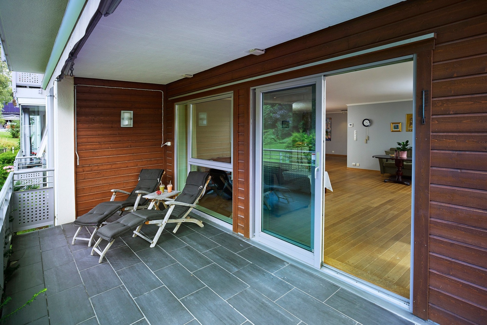 Utenfor stuen er det en flislagt terrasse, delvis takoverbygget med markise. Fra terrassen er det også adkomst ned til felles plen og hageareal Galleribilde