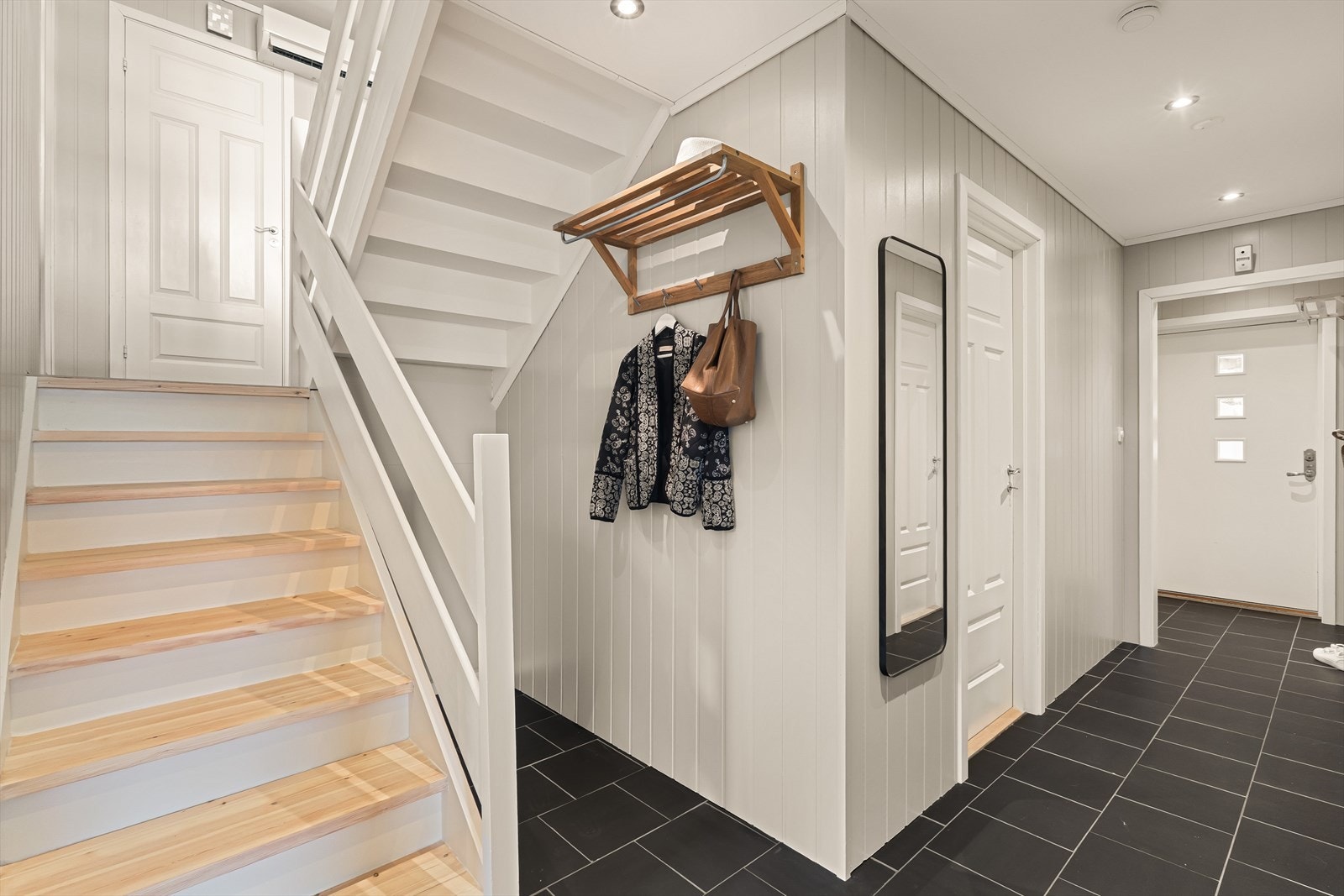 I underetasjen er det også en lys entré/gang med fliser i gulv. Det er også en egen bod i denne etasjen, perfekt for ytterligere oppbevaring. Under trappen er tilgang til krypkjeller. Merk at trinn i trappen er slipt av fagperson og oljet/ malt i 2025. Galleribilde