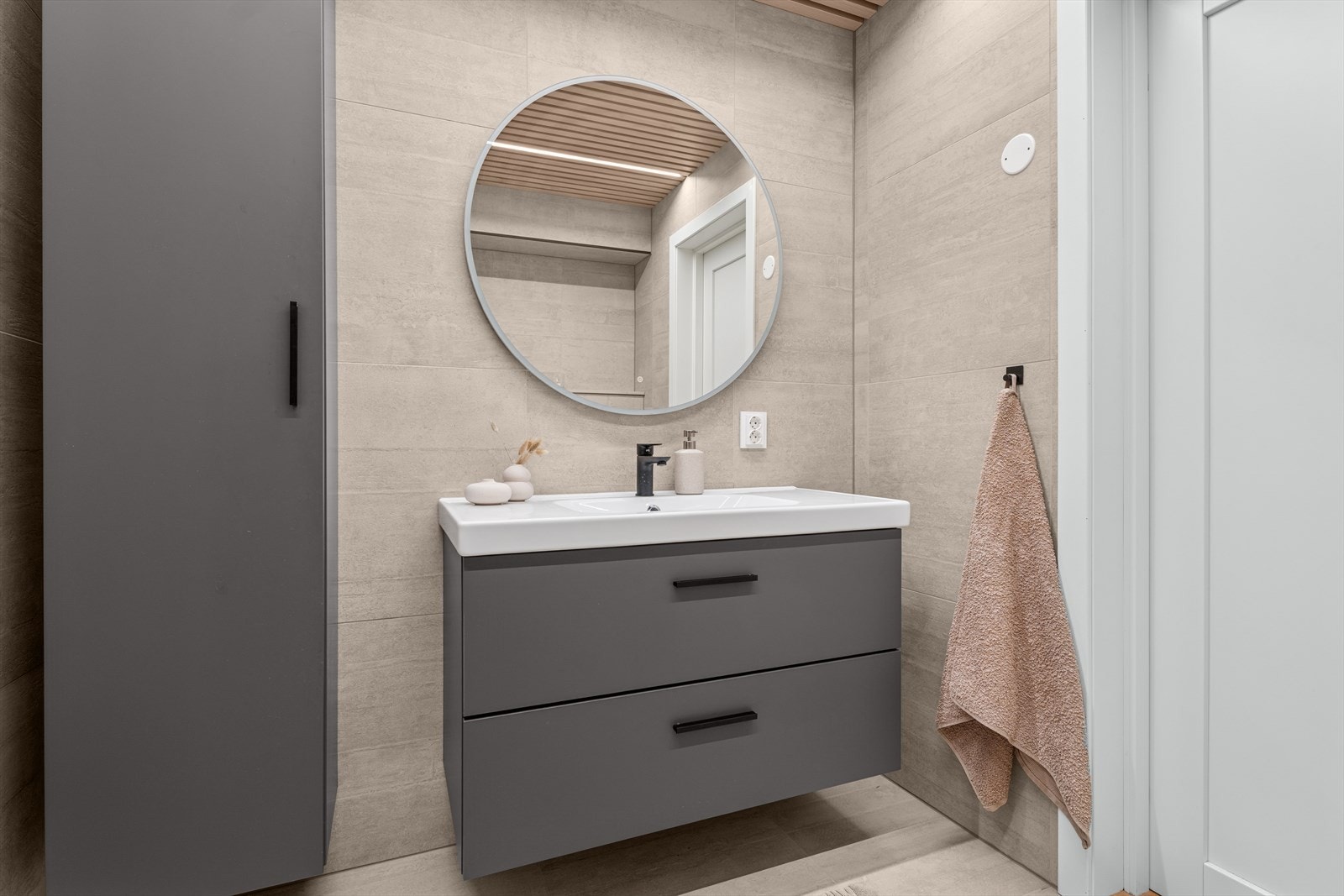 Innredningen består av heldekkende servant med underskap, speil med innebygget belysning og høyskap Galleribilde