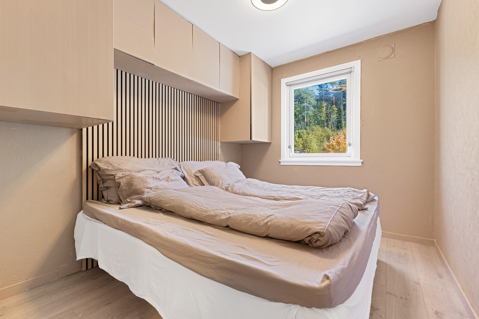 Soverom med opphengte skap og sengegavel Galleribilde