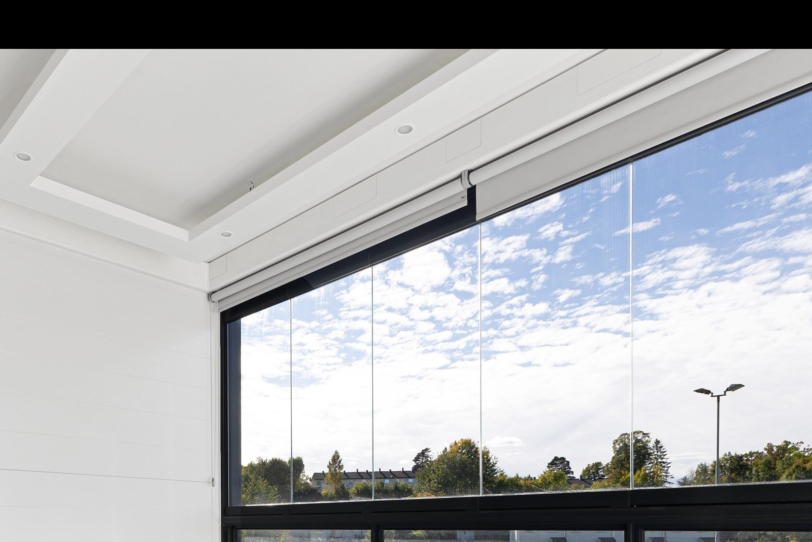 Lys og fin innglasset balkong - På gulv er det teppe og downlights i tak samt stråleovn. Galleribilde