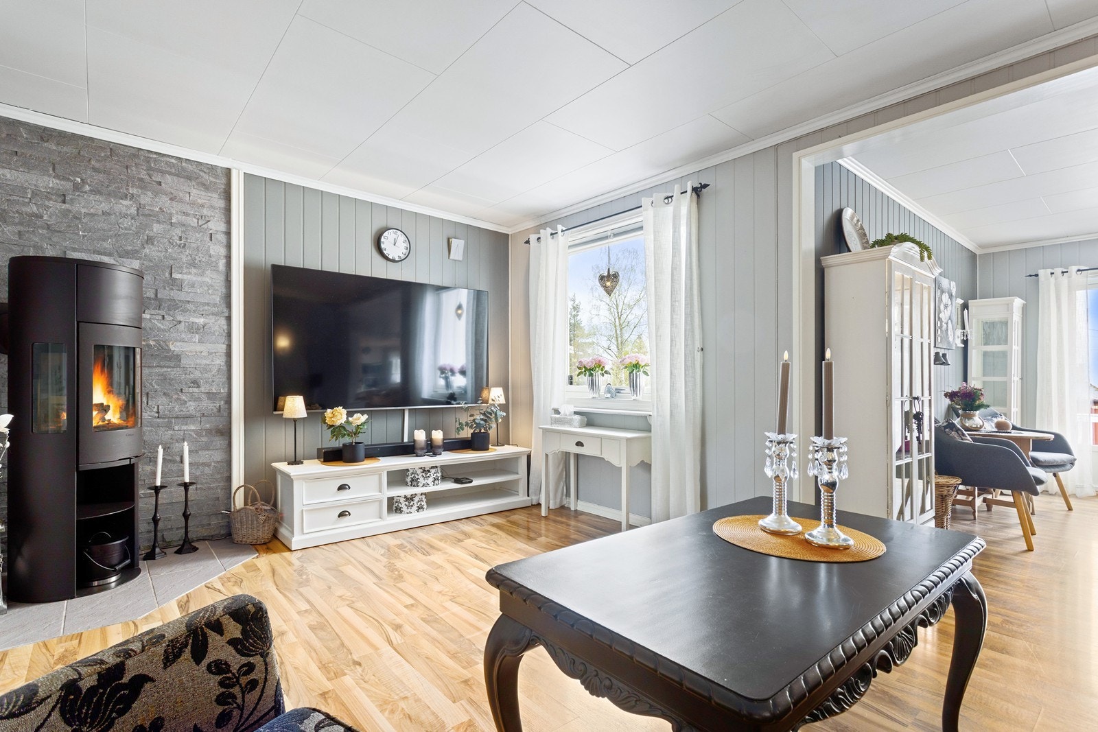 En elegant vedovn er sentralt plassert i stuen og sørger for en lun og god varme til rommet. Galleribilde