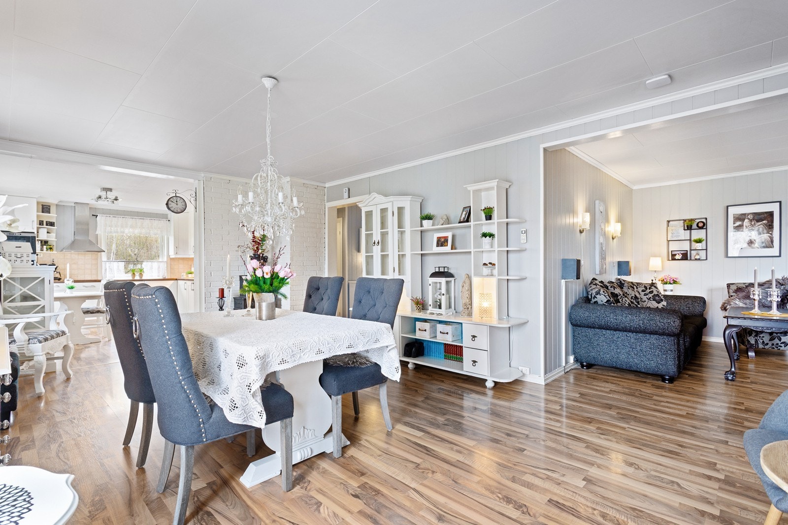 Lys og pen stue med laminat på gulv og malt panel på vegger. Galleribilde