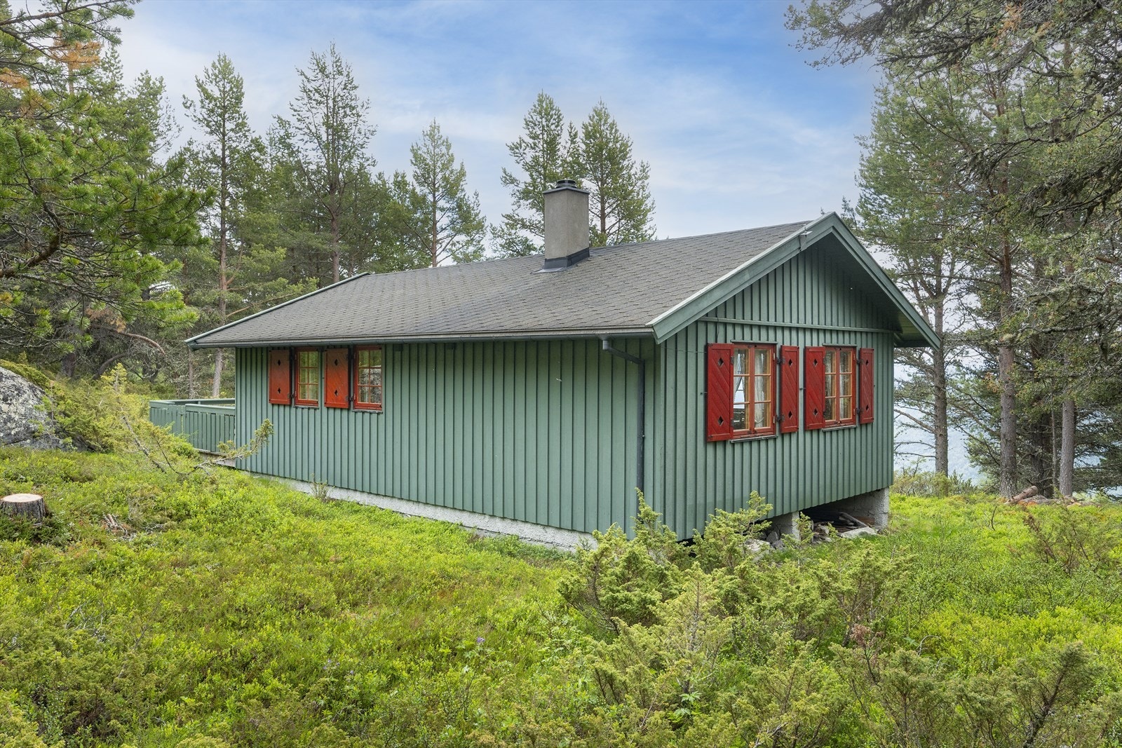 Hytten er malt i en fin grønn/blå farge. Galleribilde