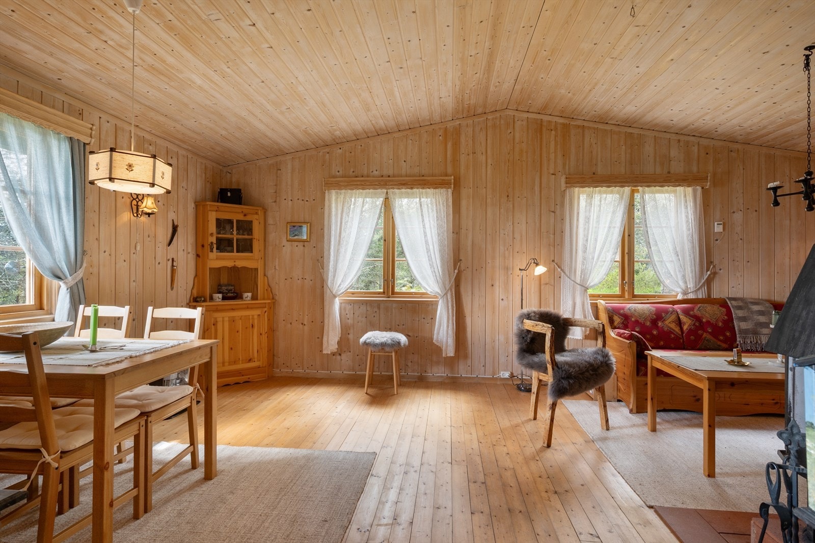 Stua er stor og romslig, med trehvite vegger, gulv og himling. Galleribilde