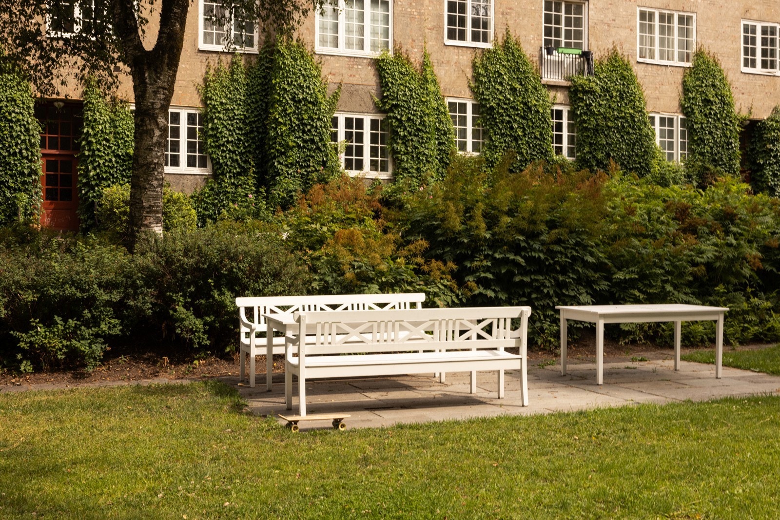 Parkmessig opparbeidet med flere sittegrupper og stor plen Galleribilde