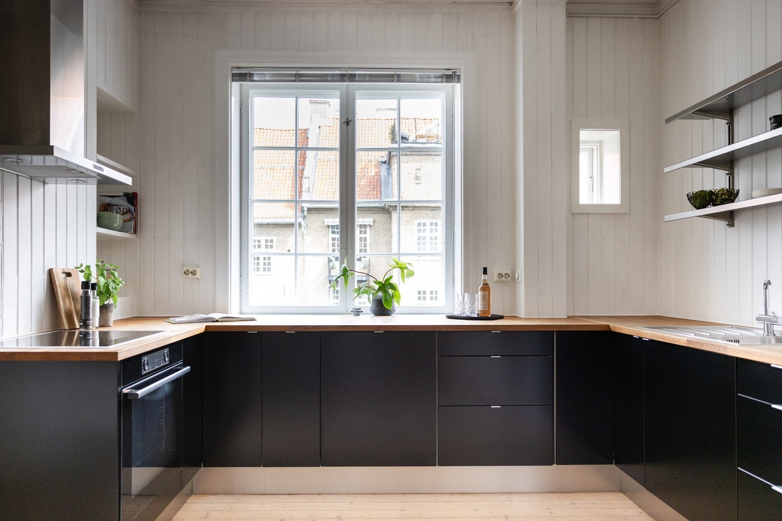 Tidløs kjøkkeninnredning med sorte slette fronter og heltre benkeplate Galleribilde