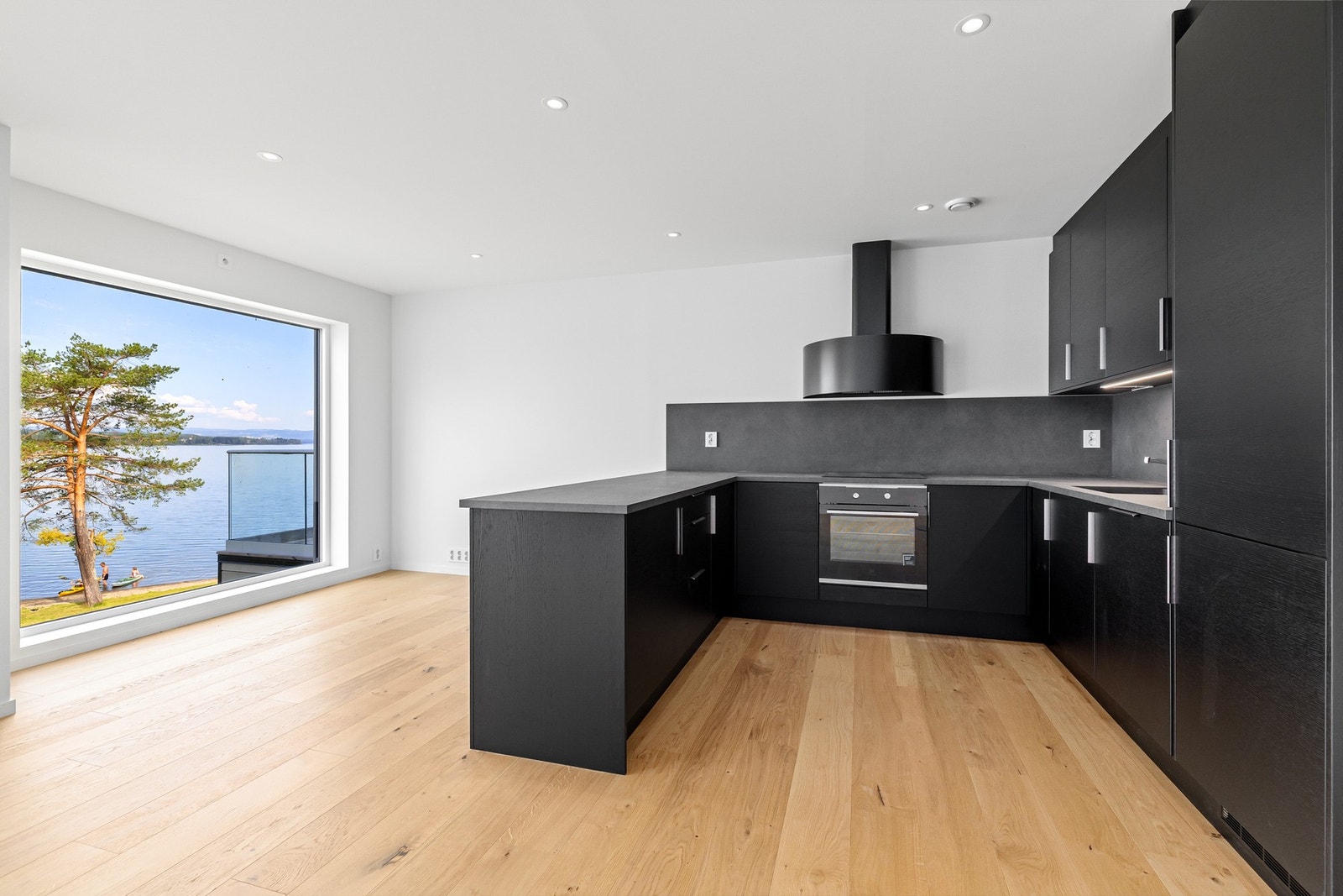 Stilrent kjøkken med mørke fronter. Her er det god plass til matlaging og sosiale måltider. Galleribilde