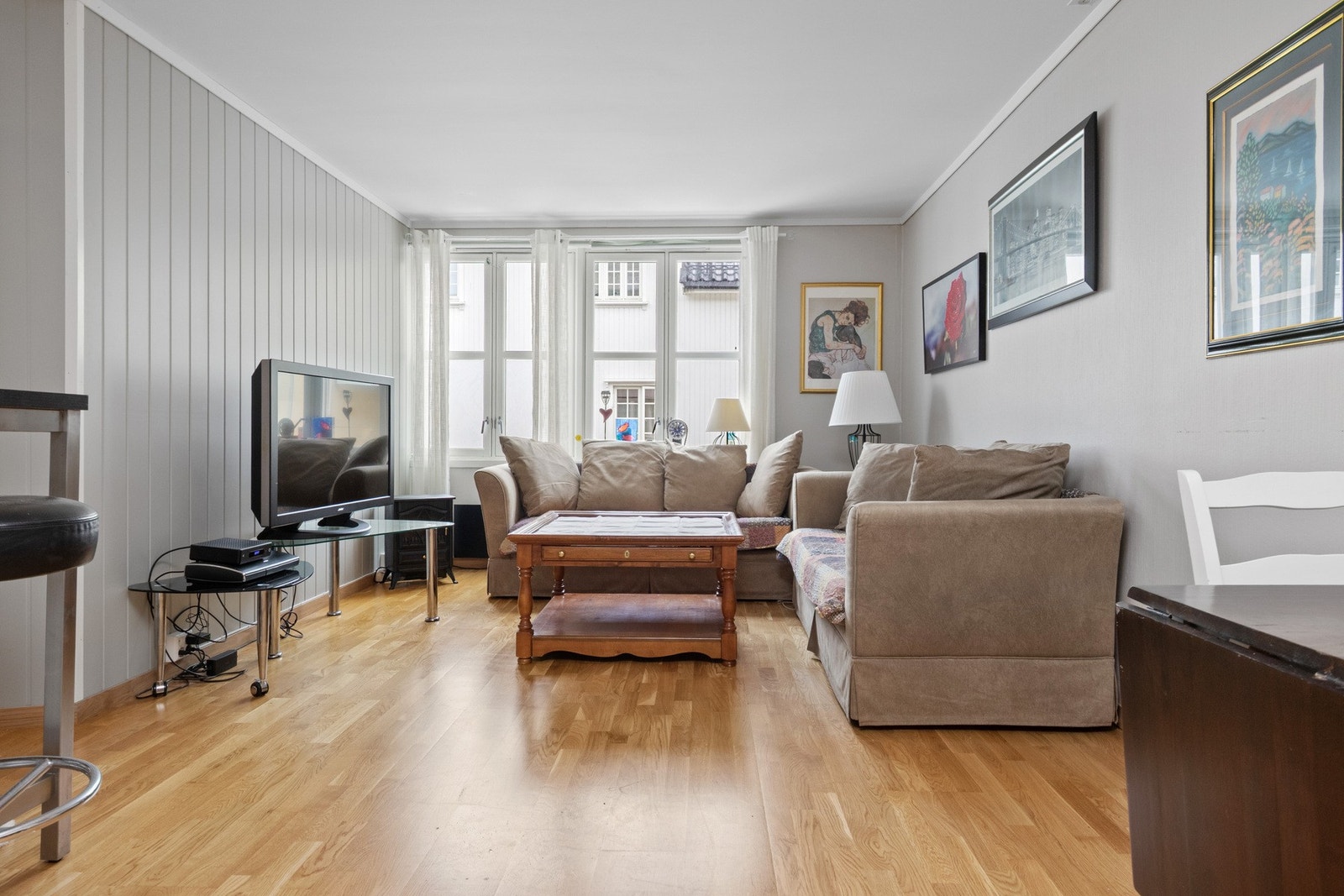Leiligheten har en lys og luftig stue med vindusrekke som gir rikelig med dagslys. Galleribilde