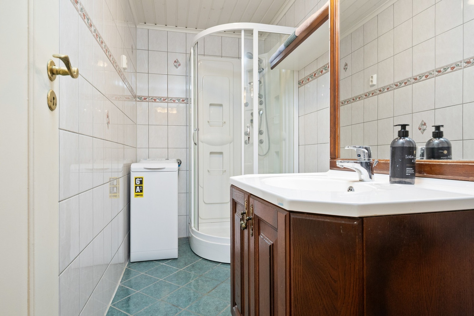 Badet ble pusset opp i 2010, har grønne fliser på gulv med gulvvarme, hvite fliser med dekorbord på veggene og hvitmalt panelhimling med plafond. Galleribilde