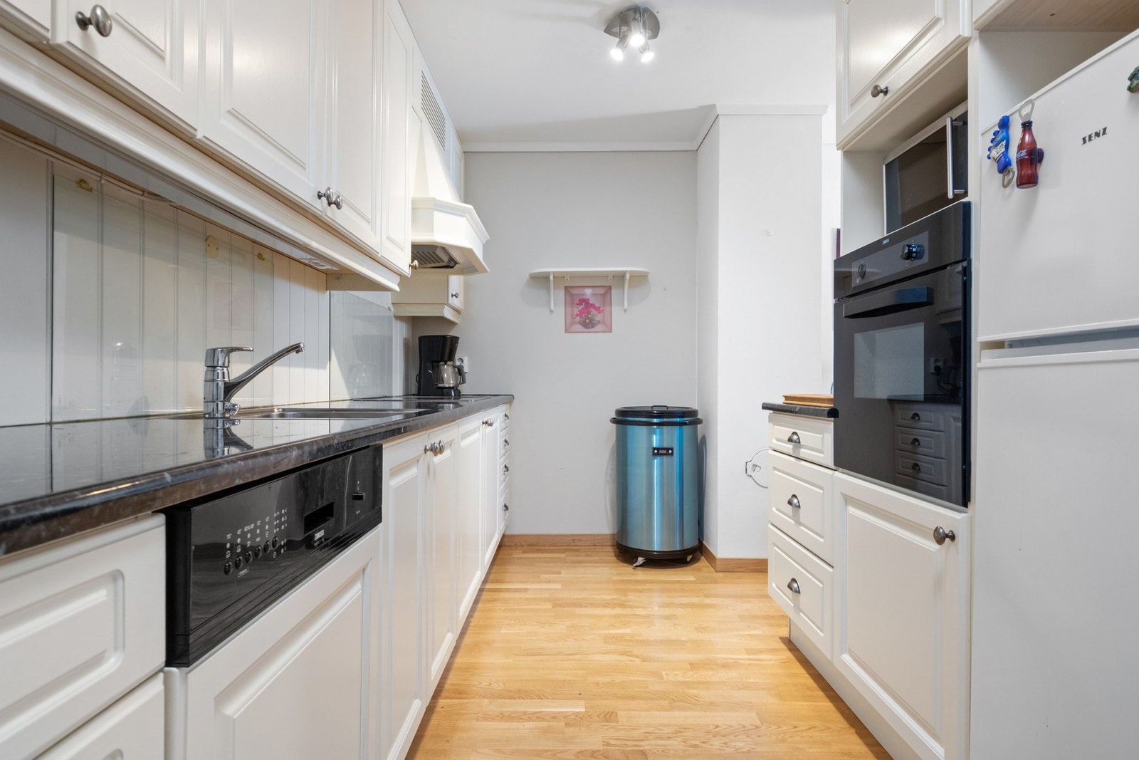 Benkeplaten er i sort laminat med nedfelt vaskekum og keramisk platetopp. Galleribilde