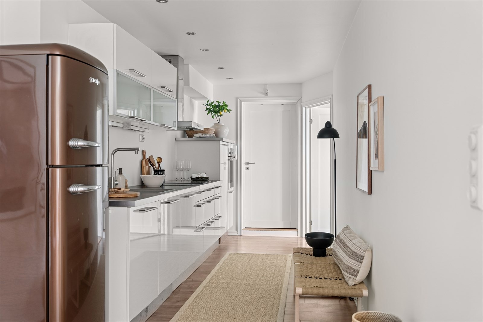 HTH-kjøkkeninnredning fra 2011 med glatte høyglansfolierte fronter, vitrinedører med frostet glass og laminat benkeplate. Galleribilde