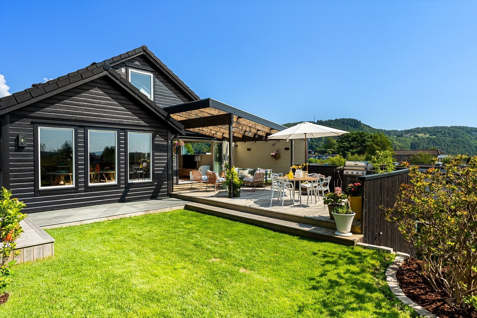 Denne hagen er av de sjeldne. Her nyter du alt fra terrasse ed glasstak, skiferplatting, drivhus og vakker belysning. Galleribilde