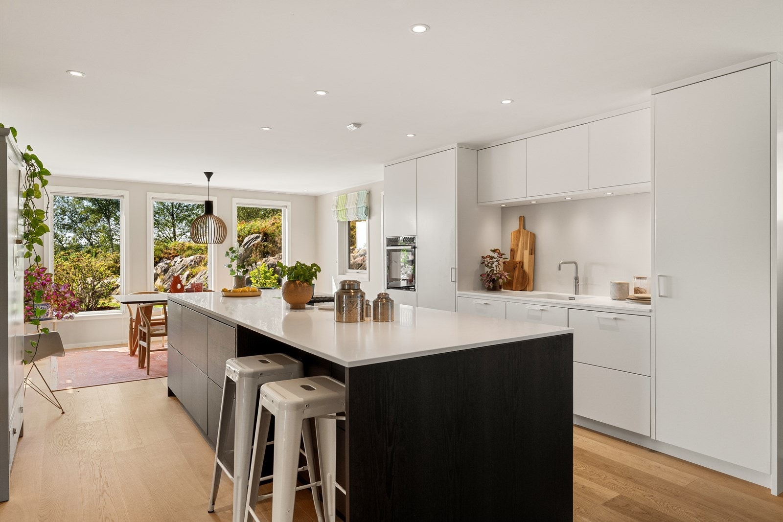 Luksus med kjøkkenøy på over 3 meter med hvit corian benkeplate og integrert platetopp med vifte i benk Galleribilde