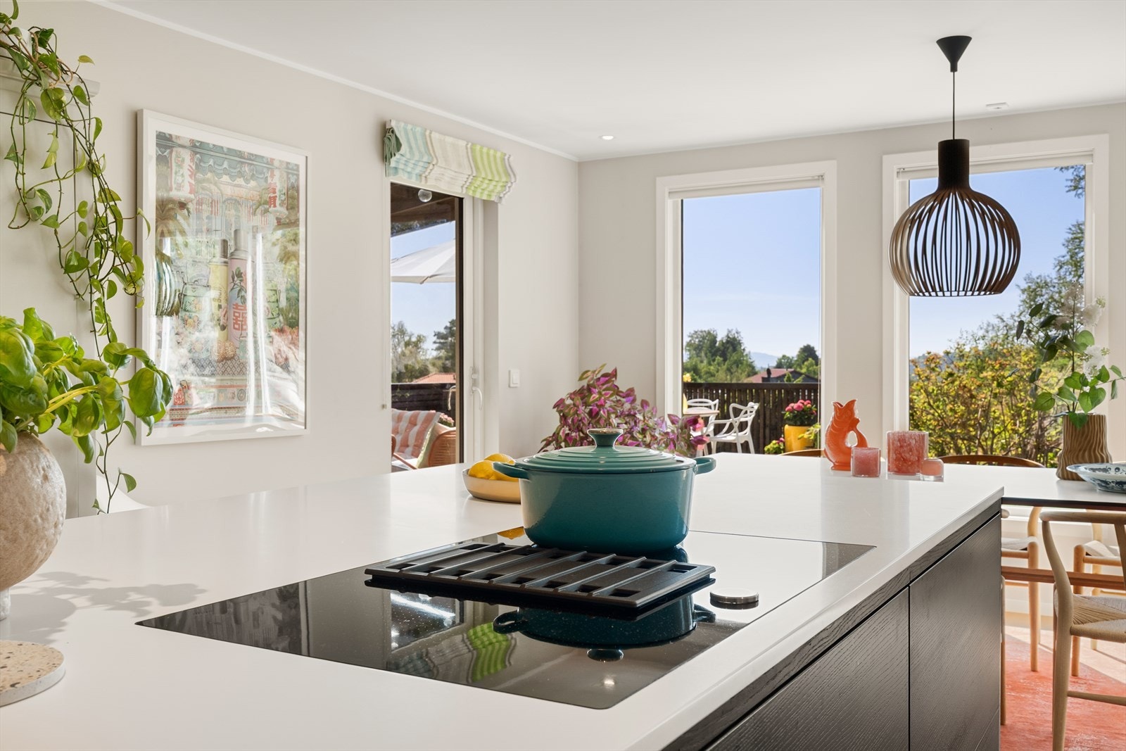 Kjøkkenøy på over 3 meter med hvit corian benkeplate og integrert platetopp med vifte i benk Galleribilde