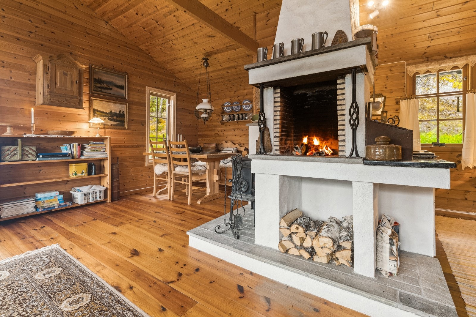 Stova har ein flott peis som skapar ein varm og innbydande atmosfære i hytta. Peisen er fint plassert i romet mellom stove og kjøkken Galleribilde