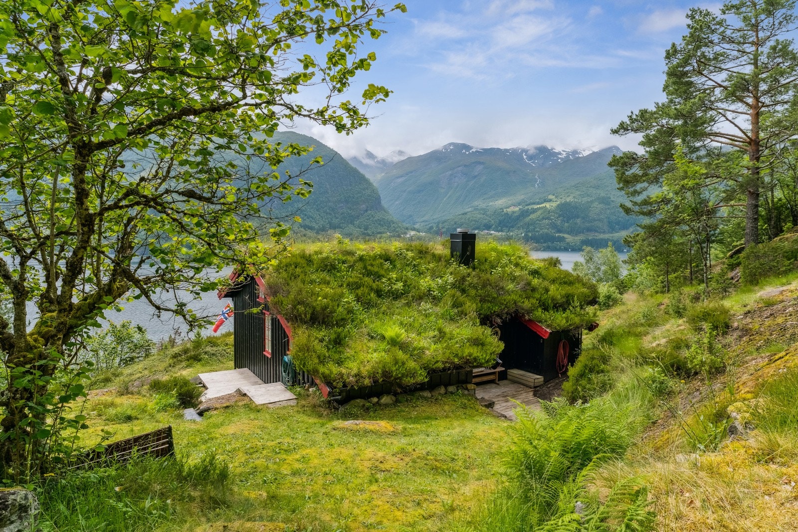 Fritidsbustaden ligg lunt og fint til i terrenget Galleribilde