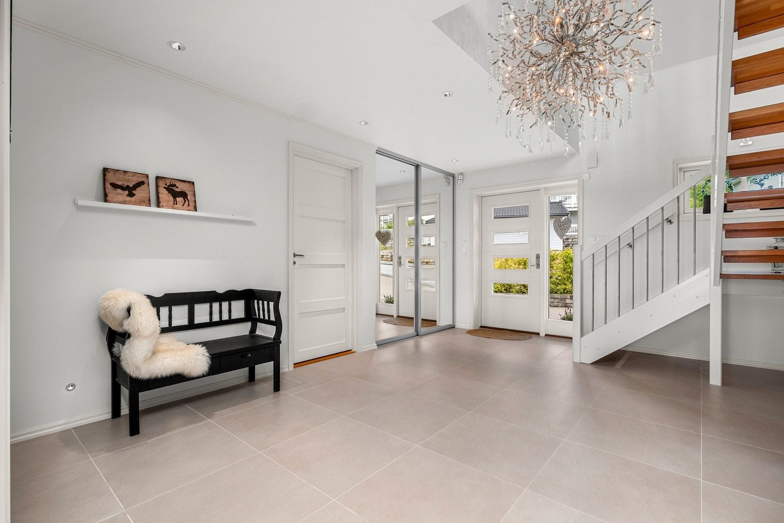 Lys og innbydende entré med fliser fra Villeroy og Boch på gulv med god plass til oppbevaring Galleribilde